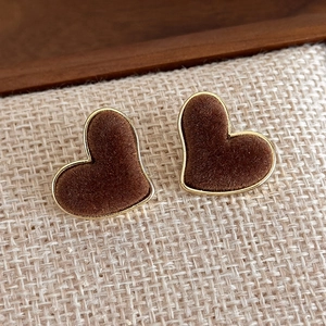 Macro shot of vintage heart velvet studs with golden frames on a rustic texture
