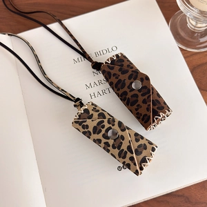Detail of leopard print lipstick holder necklace with snap button on vintage book