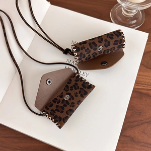 Detail of leopard print mini bag necklace showing fine stitching and snap button closure