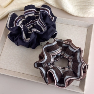 Elegant knit scrunchies in navy blue and brown set on a stylish tray for autumn