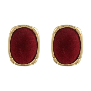 Detail of vintage gold oval earrings featuring luxury deep red velvet texture inserts