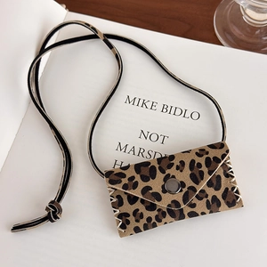 Detail of leopard print mini bag with contrast stitching and metallic snap button
