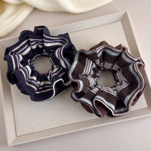 Detail view of retro striped knitted hair scrunchies in navy and brown fabric