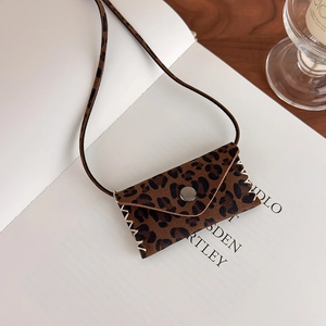 Detail of leopard print mini bag necklace with silver snap button and woven stitching