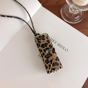 Close-up of leopard print leather lipstick pouch with manual stitching and metal snap button