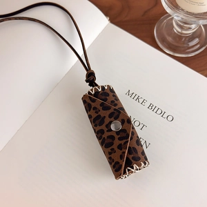 Macro shot of leopard print mini bag pendant with white stitching and silver snap button
