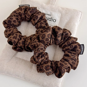 Handmade leopard print suede scrunchies set for women shown on a beige canvas bag