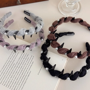 Dettaglio di cerchietti in maglia con perle in grigio, viola, caffè e nero chic