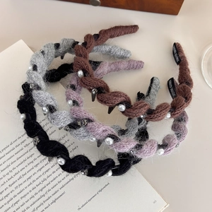 Dettaglio di cerchietti in maglia ondulata con perle e strass su pagine vintage