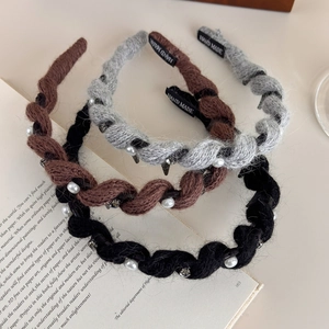 Dettaglio di cerchietti a maglia con perle e cristalli in marrone, grigio e nero di stile