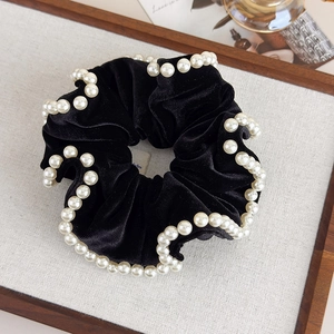 Detail of vintage black velvet scrunchie featuring elegant white pearl bead trimming