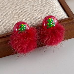 Detail von Weihnachtsbaum-Ohrsteckern mit rotem Pelzpompon und festlichem Muster
