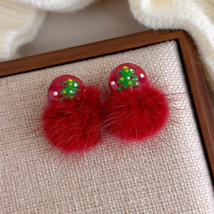 Detail der roten Weihnachtsbaum-Ohrstecker mit flauschigen Bommeln auf einem Holztablett