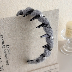 Dettaglio del cerchietto in maglia grigia con borchie punk, perle e strass luccicanti