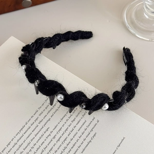 Dettaglio fascia in maglia fatta a mano con perle, borchie e etichetta Hand Made
