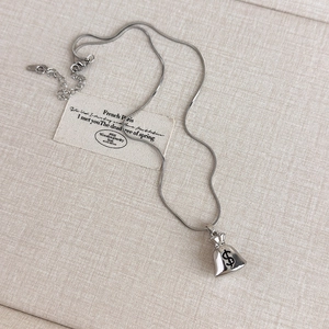 Detail of silver money bag pendant with dollar sign and adjustable snake bone chain