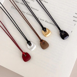 Set of five minimalist geometric pendant necklaces in various matte and glossy finishes