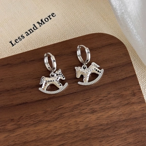 Detail view of silver Trojan horse hoop earrings with textured finish and zircon stones