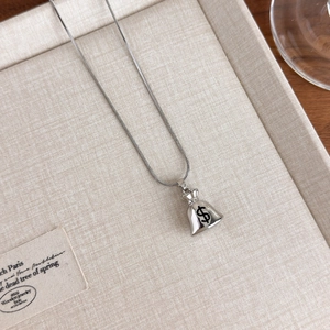 Detailed macro view of a silver money bag pendant with dollar sign on a sleek snake chain