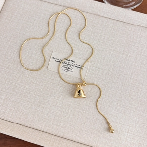 Detailed view of golden money bag pendant with dollar sign and sleek snake chain