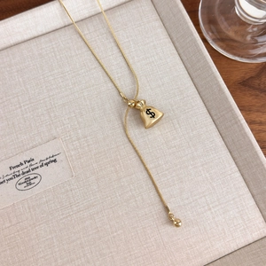 Detailed shot of golden money bag pendant with $ sign and long fringe tassel chain