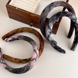 Close-up of handmade thickened wool headband with plaid patterns and bow embroidery