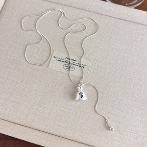 Detail of adjustable snake chain necklace with a unique money bag pendant design