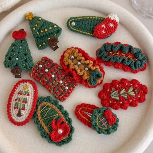 Close-up of handmade crochet Christmas hair clips with festive knitting patterns and beads
