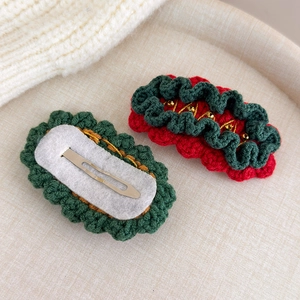 Detailed macro view of handmade crochet Christmas hair clips showing texture and metal BB clip