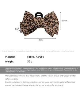 Detail view of leopard print bow hair claw clip with specific size and weight measurements