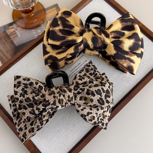 Leopard print bow hair claw clips for women featuring stylish fabric and sturdy black grip