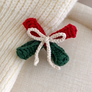 Detailed macro view of handmade crochet Christmas bow hair clip with red and green yarn texture
