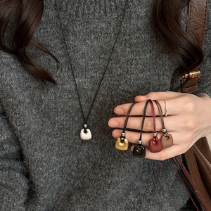 Minimalist square pendant necklace with matte finish in multiple colors on a black cord