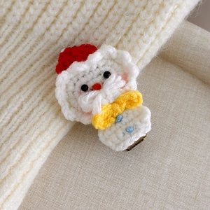 Detailed close-up of handmade crochet Santa Claus hair clip with knit texture and metal pin