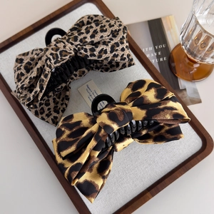 Elegant leopard print bow hair claw clips set in satin fabric with classic retro aesthetic