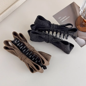 Detailed close-up of wool texture double-layered bow hair clips in grey and brown colors