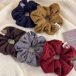 Five assorted colors of knit texture hair scrunchies with heart charm and new label
