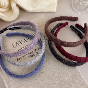 Knitted mohair headbands in various colors on a vintage book for a warm winter aesthetic