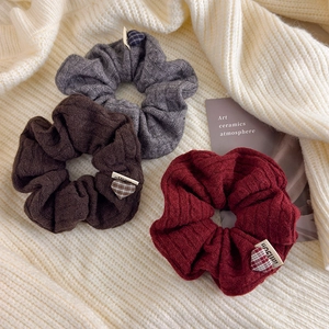 Detail view of knitted scrunchies with stripe textures and heart patches in winter style