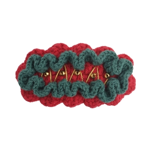 Handmade Christmas crochet hair clip with festive red and green yarn and gold bead accents