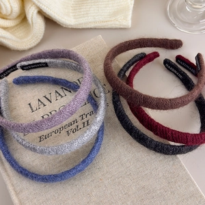 Set of slim knitted headbands in six colors with handmade label on soft fabric
