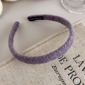 Detailed close-up of purple knit headband texture with handmade label detail