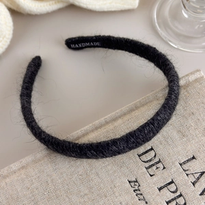 Detailed macro view of black knit wool headband texture with handmade inner label