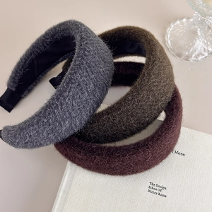 Detail of plush velvet headbands in grey, green, and brown with soft fuzzy texture