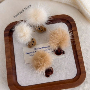 Plush bear and pom-pom earrings in beige and brown velvet on a wooden jewelry tray