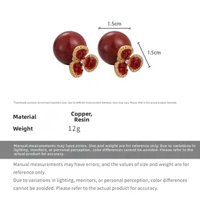 Detailed macro view of red floral pearl earrings with zircon inlay and copper petals