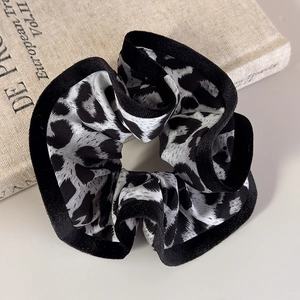 Close-up of leopard print scrunchie with black velvet trim on a vintage book