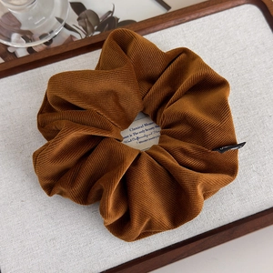 Vue détaillée d'un chouchou en velours côtelé marron caramel avec texture côtelée