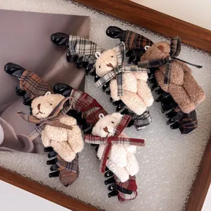 Détail des pinces à cheveux ourson en peluche à carreaux en quatre coloris variés