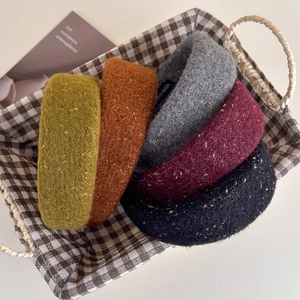 Detail view of thickened tweed headbands with gold silk texture and handmade label